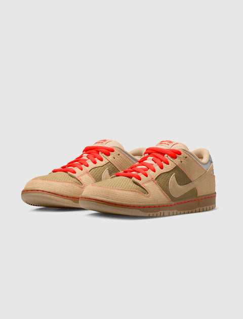 Beige and olive low-top sneakers with bright orange laces on a light background