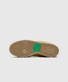 Tan sneaker outsole with green Nike detail, displayed on a neutral background