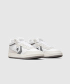White and gray mid-top sneakers with star and chevron logo on side, streetwear style