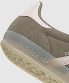 Close-up of suede sneaker heel with translucent sole, pink leather accent, and adidas logo