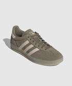Olive green suede sneaker with pink stripes and gum sole, side view on white background