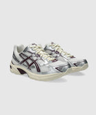 Silver and cream athletic sneakers with purple accents, mesh panels, and lace-up design