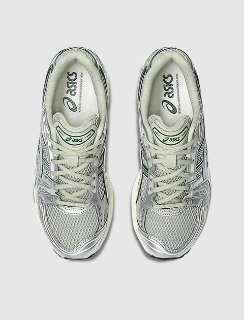 Overhead view of silver and green mesh Asics running sneakers on a light gray background