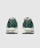 Rear view of green and white athletic sneakers with mesh and gel cushioning details