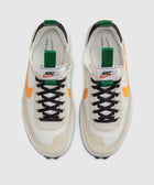 White and beige sneakers with orange swoosh and green pull tab, top view