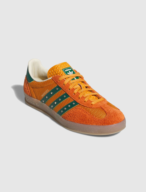 Orange and green low-top sneaker with suede upper, gum sole, and striped side detailing