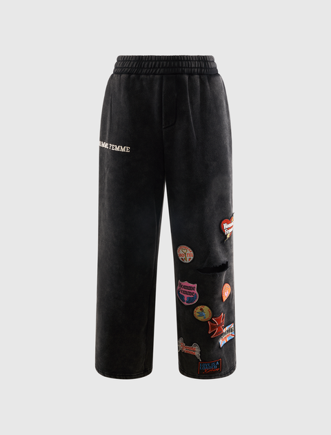 Black streetwear sweatpants with colorful embroidered patches and elastic waistband