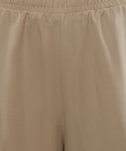 Close-up of beige men's streetwear shorts with elastic waistband and soft fabric