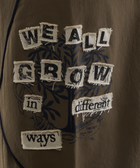 Brown streetwear shirt with sewn patchwork text saying 'We all grow in different ways'.