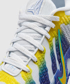 Close-up of white sneaker with blue, yellow, and green accents, mesh upper, and textured sole