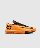 Low-top orange basketball sneaker with black laces, black logo, and visible Air unit sole