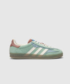 Green and blue suede sneaker with white stripes, brown heel tab, gum sole, side view on white background