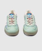 Mint green and blue low-top sneakers with white stripes and gum soles, front view