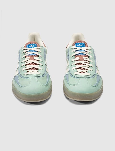 Mint green and blue low-top sneakers with white stripes and gum soles, front view