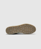 Bottom view of green and blue sneaker with textured outsole and circular grip pattern