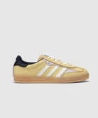 Yellow suede Adidas sneaker with white stripes, gum sole, and navy heel panel