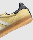 Yellow suede sneaker with white stripes, gum sole, and navy heel detail