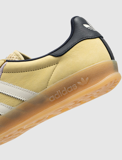 Yellow suede sneaker with white stripes, gum sole, and navy heel detail