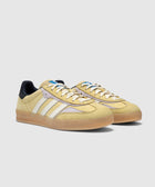 Yellow and purple suede sneakers with white stripes, gum sole, and black heel tab on white background