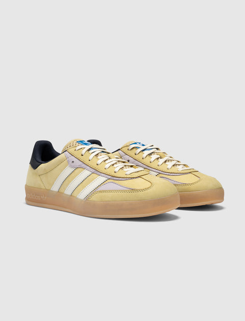 Yellow and purple suede sneakers with white stripes, gum sole, and black heel tab on white background