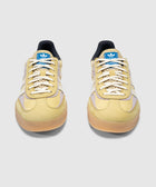 Yellow and lilac Adidas Gazelle sneakers with gum sole, mesh tongue, and blue logo patch