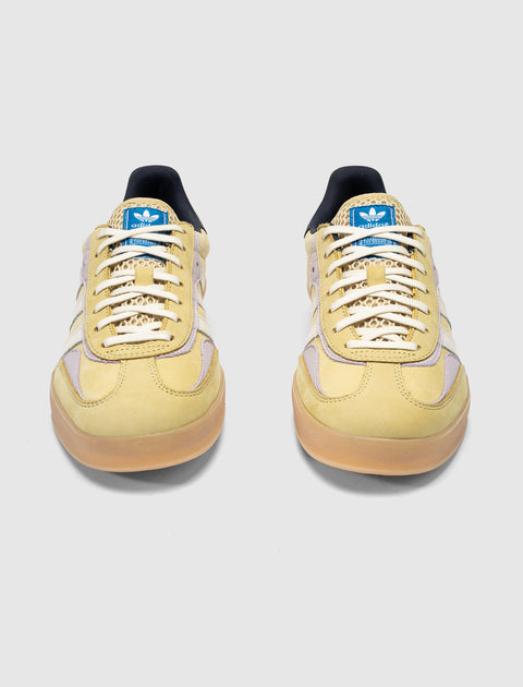 Yellow and lilac Adidas Gazelle sneakers with gum sole, mesh tongue, and blue logo patch