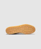 Gum sole sneaker bottom with circular traction pattern and logo, viewed on white background