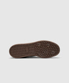 Brown gum sole of a men's sneaker with textured grip and circular tread pattern