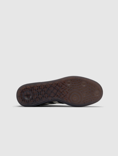 Gum sole of a sneaker with textured tread pattern on a plain light background