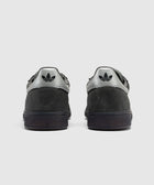 Gray and cream suede low-top sneakers, viewed from the back, with black logo on heel tab