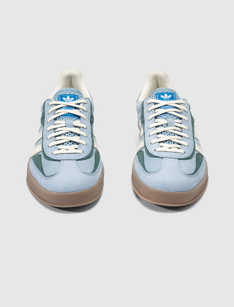 Light blue and green suede sneakers with gum soles and white laces, front view
