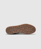 closeup of gum sole with circular tread pattern on blue and green sneaker