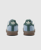 Blue and green low-top sneakers with white logo on heel and gum sole, rear view