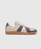Beige and purple leather sneaker with gum sole, side view on plain background