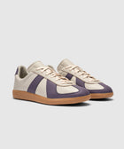 Cream and purple low-top sneakers with gum sole on white background