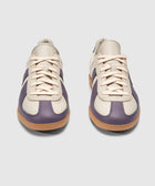 Pair of cream and purple low-top sneakers with gum soles on a plain background
