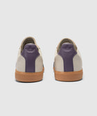 Back view of beige and purple sneakers with gum soles on a white background