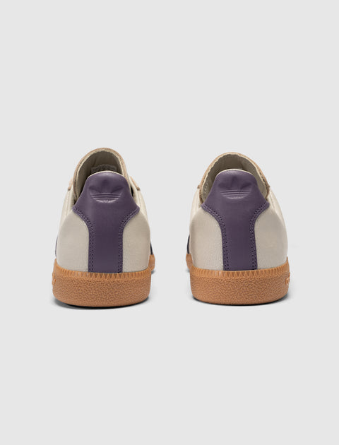 Back view of beige and purple sneakers with gum soles on a white background