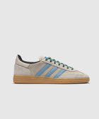Beige and blue suede sneaker with gum sole and green laces on white background