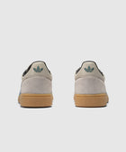 Rear view of grey and blue suede sneakers with gum soles and teal heel logo