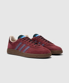 Maroon suede low-top sneakers with purple stripes and brown sole, side and front view