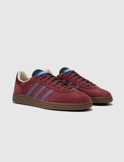Maroon suede low-top sneakers with purple stripes and brown sole, side and front view