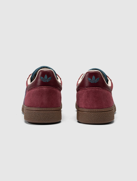 Red and purple suede sneakers with blue logo, gum sole, viewed from the back on white background