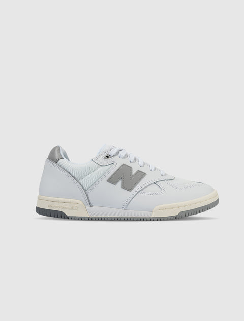 White and grey leather low-top sneaker with mesh panels and lace-up closure on white background