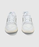 Pair of white and gray low-top lifestyle sneakers with laces on a plain background