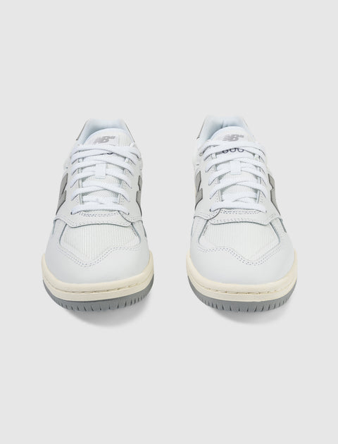 Pair of white and gray low-top lifestyle sneakers with laces on a plain background