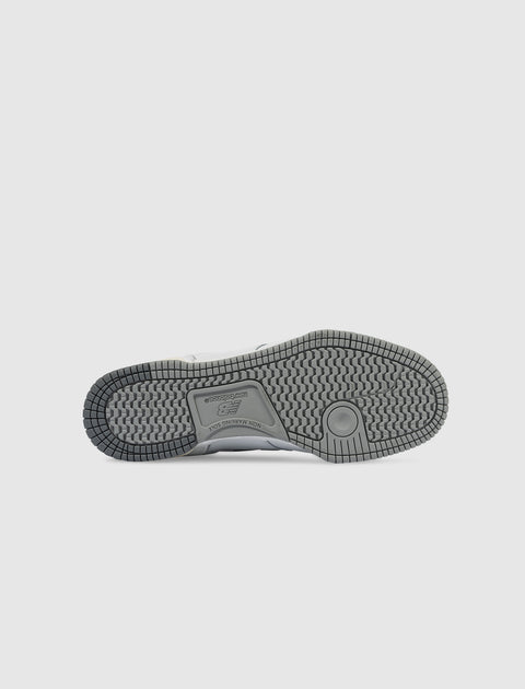 Gray rubber outsole of a men's sneaker with detailed tread pattern on white background