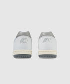 Rear view of white and grey low-top sneakers with logo on heel, grey outsoles