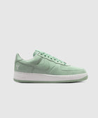 Light green low-top sneaker with textured leather upper, white sole, and side logo on heel