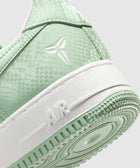 Mint green Nike Air Force 1 sneaker with textured upper and white sole, closeup view